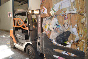 De heftrucks transporteren de papierbalen met de balenklem naar het inpandige bulkmagazijn